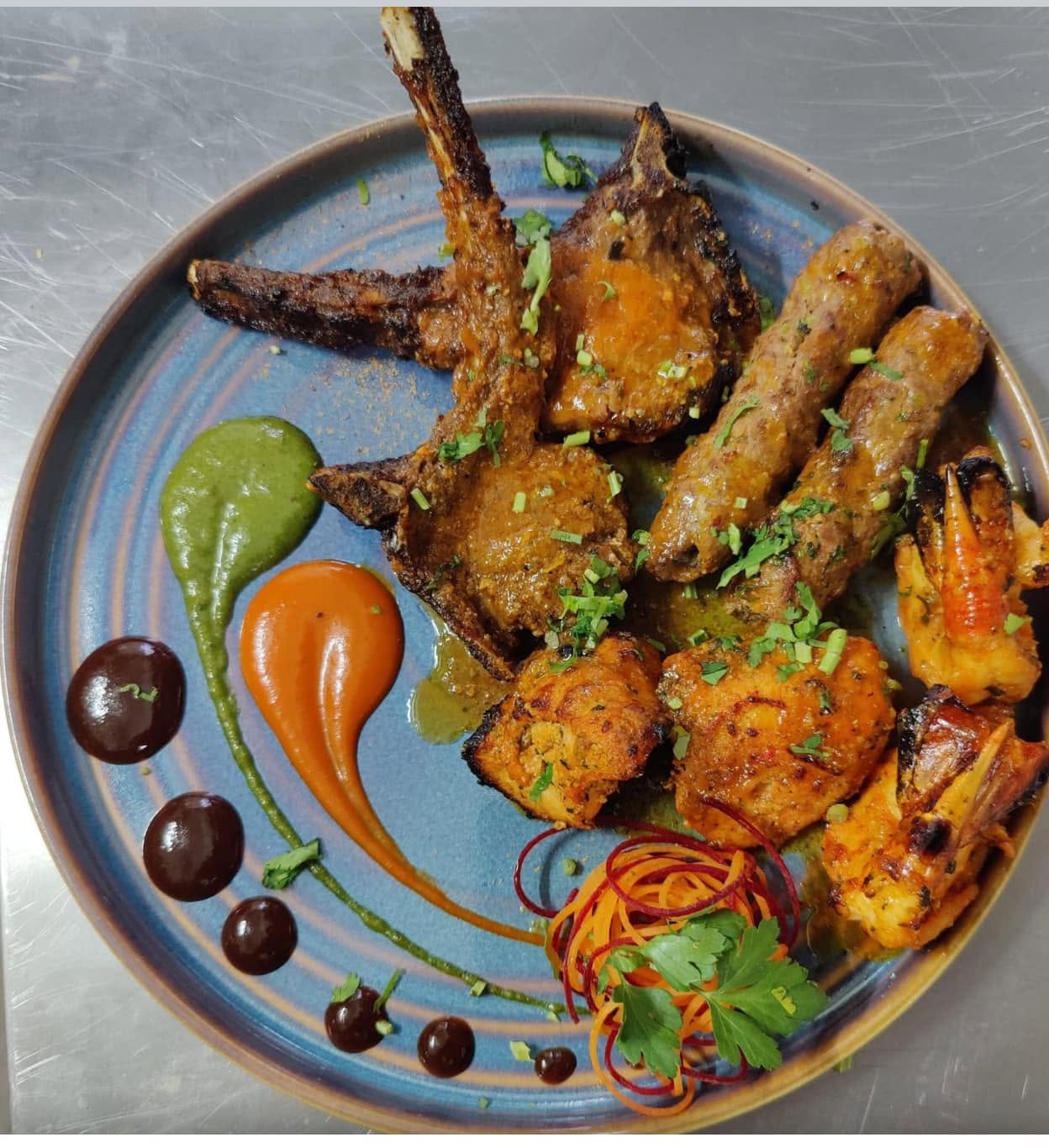 A colourful mixed grill of lamb chops, kebabs, chicken and prawns